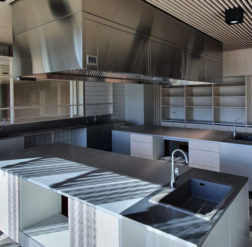 Kaasaegne õpperuum Viimsi Noorte Talentide Koolis, kus on avarad tööpinnad, mitu valamut ja suur metallist kubu.