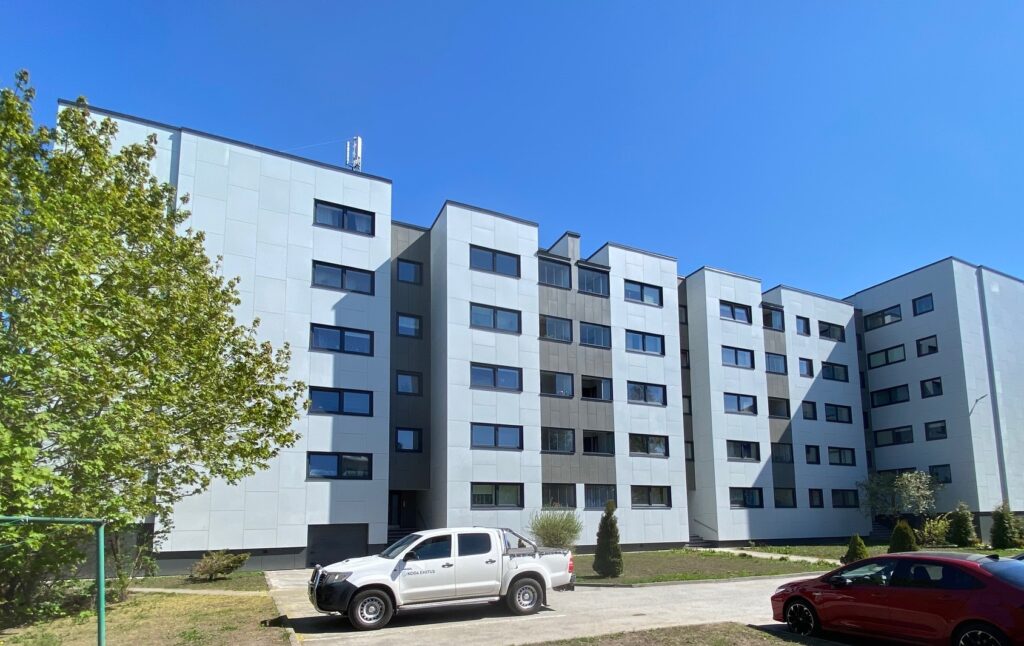 Allika 1 renoveeritud kortermaja, millel on hele fassaad. Esiplaanil haljastus ja pargitud sõidukid.