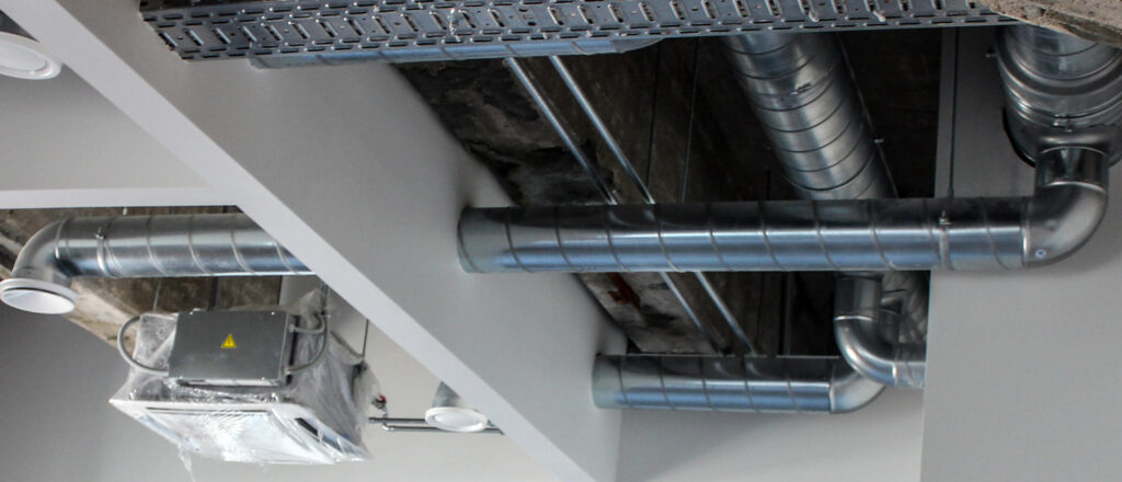 Ventilatsioonisüsteemi paigaldus, esiplaanil metallkanalid ja lae all paiknev ventilatsiooniseade.