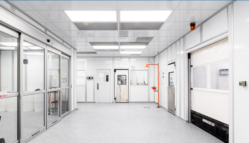 Tallinna Farmaatsiatehase steriilne tootmisruum liuguste, siledate paneelseinte ja eredalt põleva laevalgustusega.